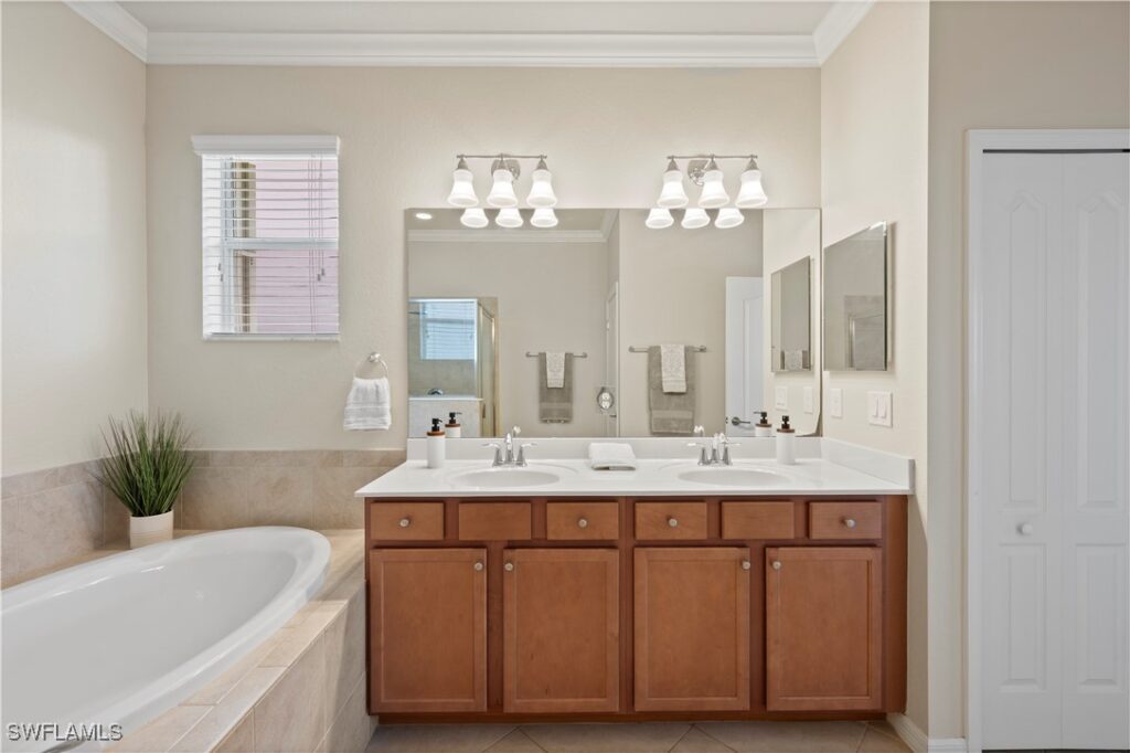 Photo of the ensuite bathroom featuring soaking tub and wooden cabinetry.