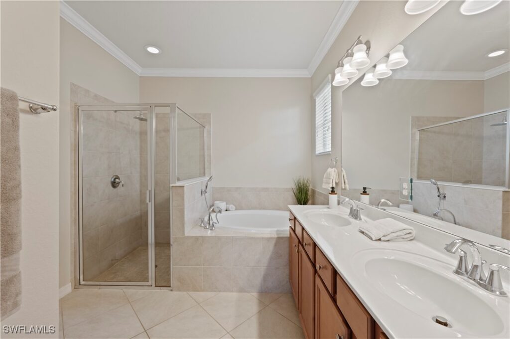 Photo of the ensuite bathroom featuring soaking tub and wooden cabinetry.